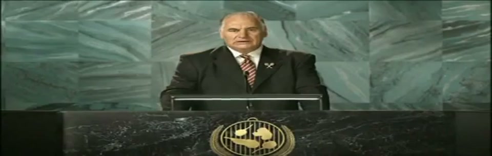 Sam Kekovich UN Speech (2010), scene 5 at 01:07: Kekovich's speech reaches its crescendo. The music swells with patriotic fervor. He speaks with utmost seriousness, as if expecting a Nobel Prize.
