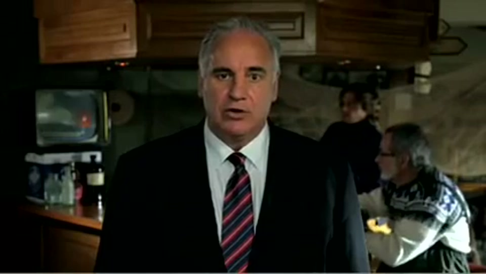 Address to the United Nations of Australia (2011), scene 1 at 00:09: The ad opens on Sam Kekovich, dressed in a dark suit and tie, standing in the middle of the Roman Forum. The lighting is dramatic, suggesting an important historical moment.