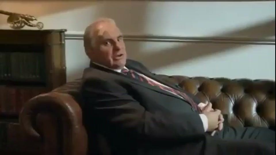 Lambnesia (2013), scene 8 at 01:23: The scene cuts back to Kekovich on the chesterfield sofa. He looks to the side, as if coming out of a dream or hallucination, and then directly to the camera.