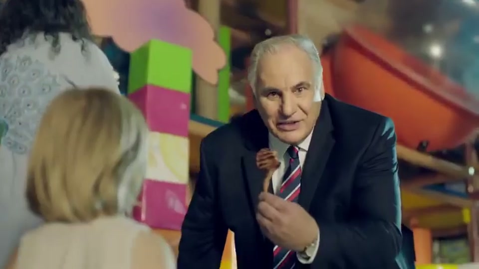 Generation Lamb (2014), scene 3 at 00:25: Kekovich approaches another family: two parents dressed in hippie-style clothing and their young son, who is wearing a singlet that says "Vegan and Proud." The parents are admiring a small potted plant.