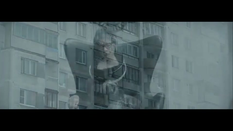 Operation Boomerang (2016), scene 1 at 00:22: The ad opens on a vast, grey, Soviet-era apartment block in a bleak, snowy landscape. The mood is oppressive and cold. A young woman with glasses peers nervously from behind a curtain.