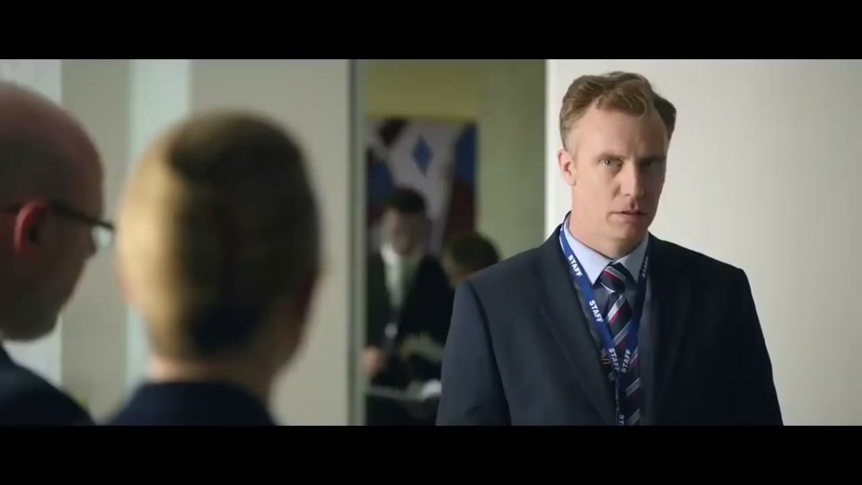 Unite Australia and New Zealand (2019), scene 2 at 00:37: The scene abruptly cuts to a bright, sterile, modern government office. A group of bureaucrats in contemporary suits stand around a table with a similar map. The lead bureaucrat, "Gary," laments Australia's state.