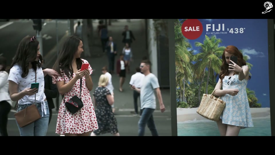 Lambalytica (2020), scene 1 at 00:07: The ad opens with an aerial shot of Sydney, transitioning to two young women walking down a city street, engrossed in their phones.