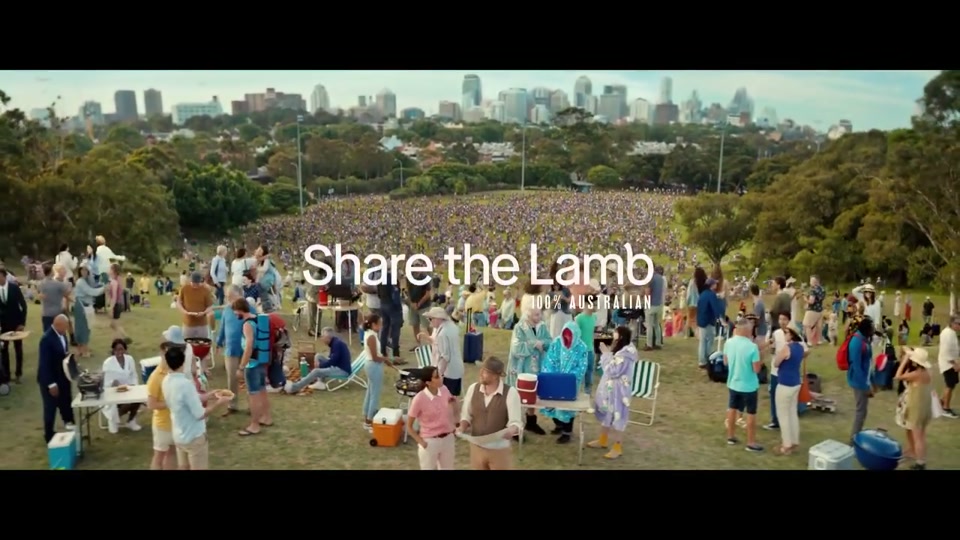 The Lost Country of the Pacific (2022), scene 6 at 02:53: A packed airport arrival hall with a "WELCOME TO AUSTRALIA" sign. Happy people stream out. The scene shifts to a massive, sunny outdoor barbecue with hundreds of people. The professor and his student are there.