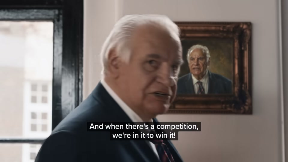 Happiness Index (2026), scene 2 at 00:28: Kekovich paces his office angrily, looking at a portrait of himself. His aides look worried. In the background, a taxidermied kangaroo wearing boxing gloves is visible.